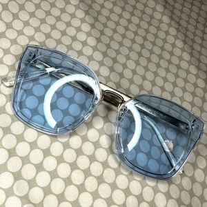 Sunglasses with blue - ish glass tint with silver arms.